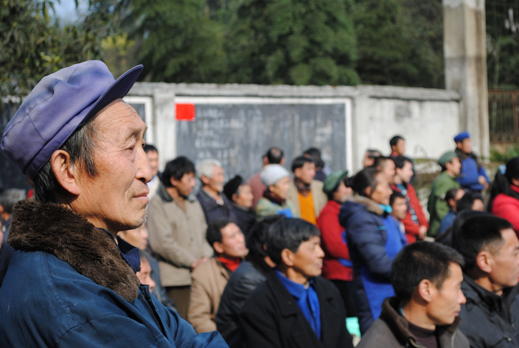 A voter listens to a speech by one of the candidates.