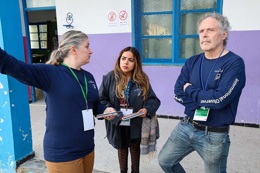 Observers stand outside a polling station.