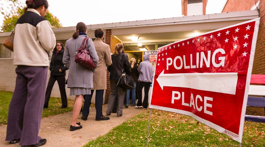 A line of voters extending out the door of a polling location.