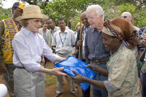 President and Mrs. Carter give a long-lasting insecticidal bed net, which prevents malaria, to Mrs. Hlmenlike, who hosted the Carters in her home during their tour of the Center's health work in the remote village of Afeta in southwest Ethiopia.