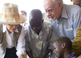 Jimmy and Rosalynn Carter watch as a health worker dresses a child's extremely painful Guinea worm wound.