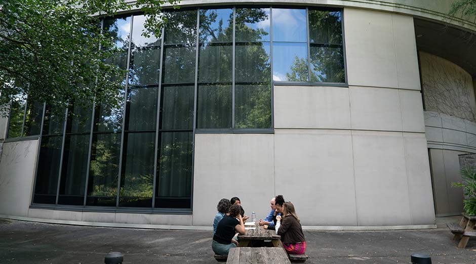 Participants sit at a picnic table outdoors.