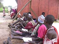 People wait outside the clinic for surgery to correct trichiasis.