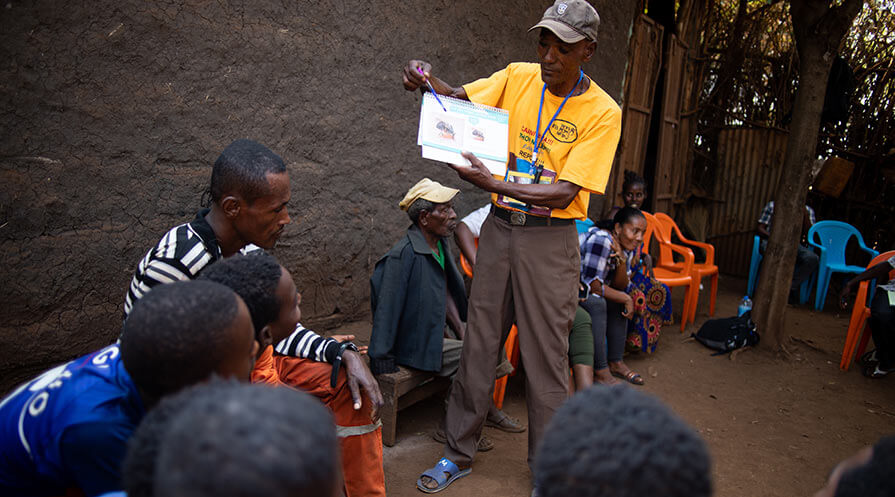 CDD Alemu Orebo provides a health lesson with the authority of a sports coach as part of mass drug administration activities for river blindness and lymphatic filariasis in the Gambella region’s Abobo District.